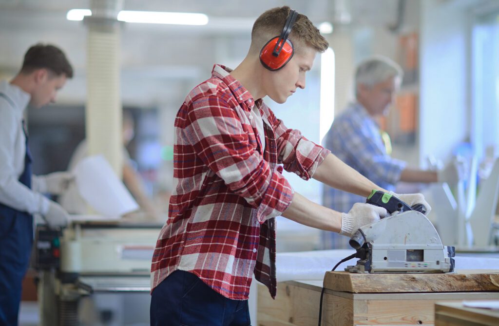 Man working at machine wearing ear defenders